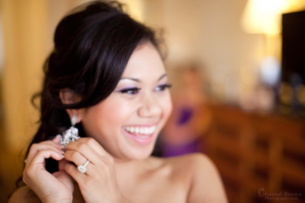 bride happily giggling and putting on diamond earrings at Fairmont hotel in Dallas bride happily giggling and putting on diamond earrings at Fairmont hotel in Dallas