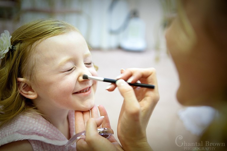 bride putting on makeup on daughter smiling at grey stone chapel getting ready lawton wedding