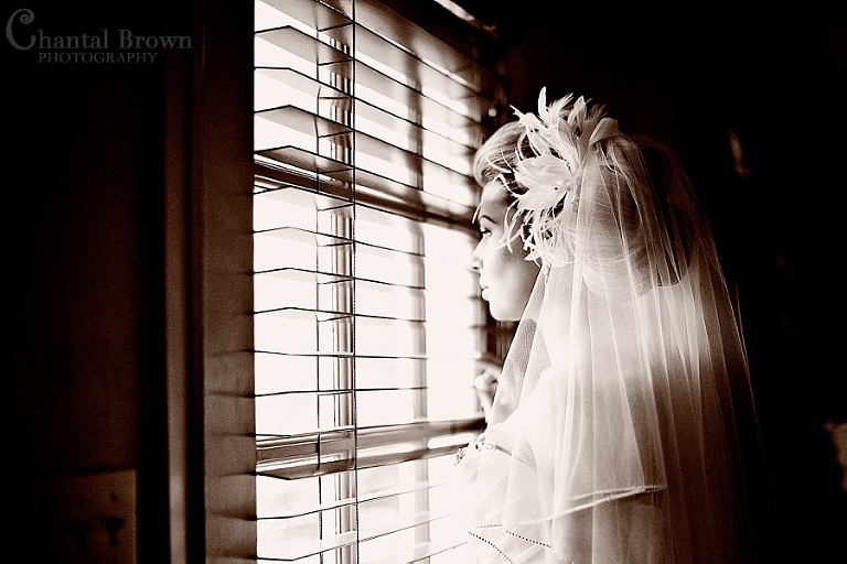 bride looking outside southfork ranch wedding window in Parker Texas