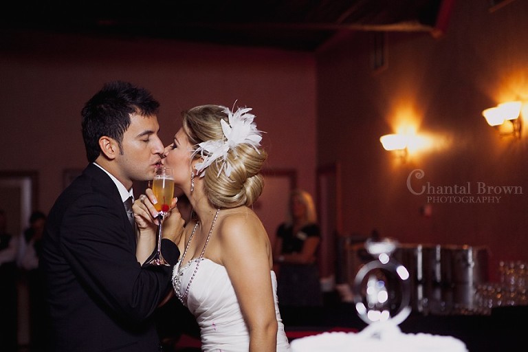 bride and groom kissing next to wedding cake at Southfork Ranch wedding in Parker TX