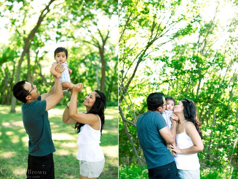 Mother and father playing with the baby jumping up and down at the park
