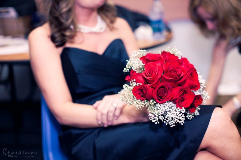 Waters Edge Church in Frisco getting ready bridesmaid holdingred rose bouquet
