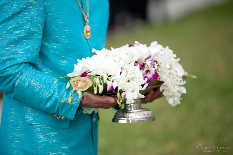 The groom holding fresh white and purple orchids on top of banana branch. He's getting ready parade to the bride's house.