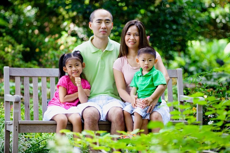Family portrait session setting on bench at Dallas Arboretum in forest garden