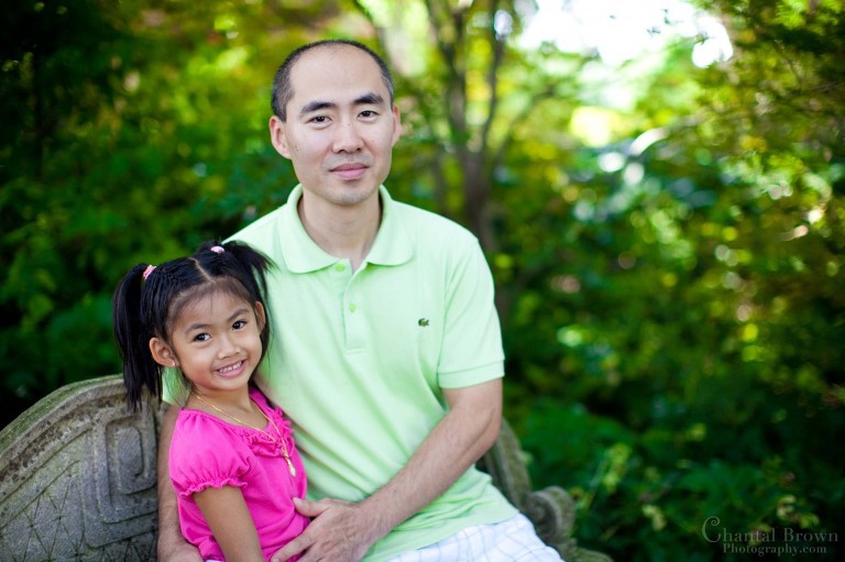 Father and daughter setting at beautiful park in Dallas Arboretum portrait session with gorgeous trees