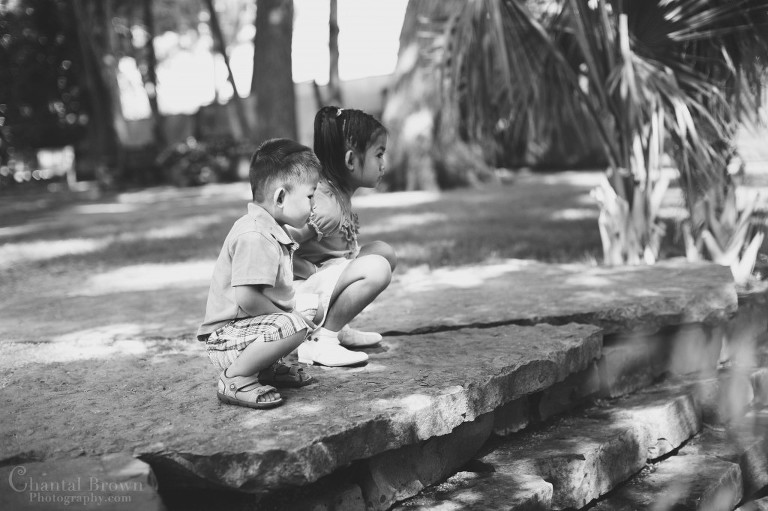 Brother and sister watching fish swimming in the pond at Dallas Arboretum black and white portrait