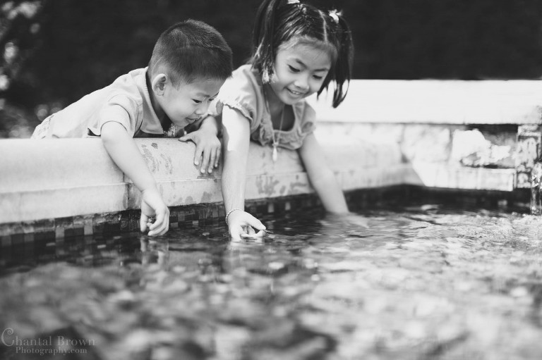 children happy, smiling, playing in water fountain at Dallas Arboretum and Botanical Garden  black white portrait