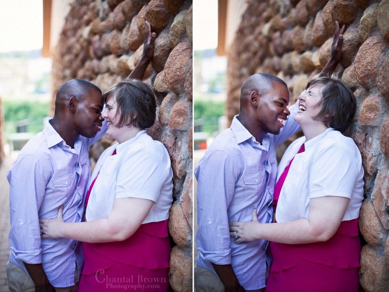 Engagement couple laughing leaning on cobblestone gold brown and red rounded brick wall in Medicine Park in Lawton Oklahoma portrait photography
