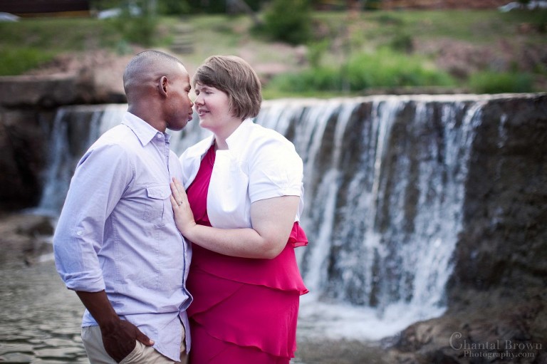 Engagement standing by beautiful waterfall in Medicine Park in Lawton Oklahoma portrait