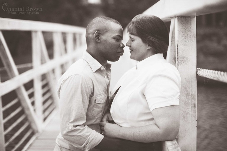 Engagement couple kissing on old white bridge in Medicine Park in Lawton Oklahoma portrait