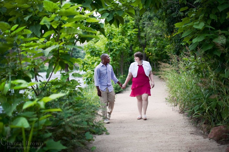 Gorgeous engagement couple walking by beautiful green trees in Medicine Park in Lawton Oklahoma