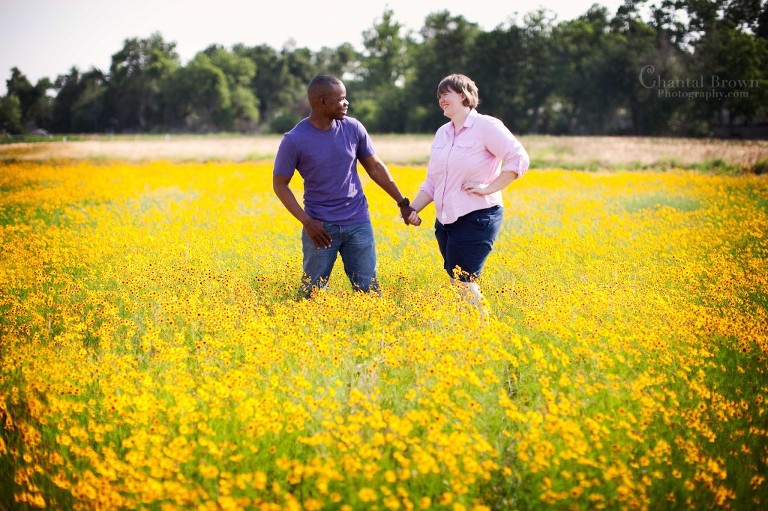 engagement couple holding hands in gorgeous yellow flower field in Lawton Oklahoma photography