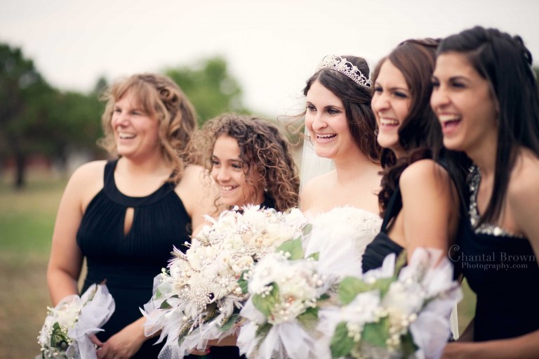bride laughing holding brooch bouquet outside Holy Family Catholic Church in Lawton OK