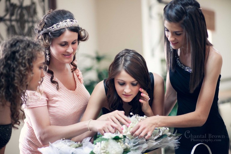 bride showing off brooches in bouquet to bridesmaid