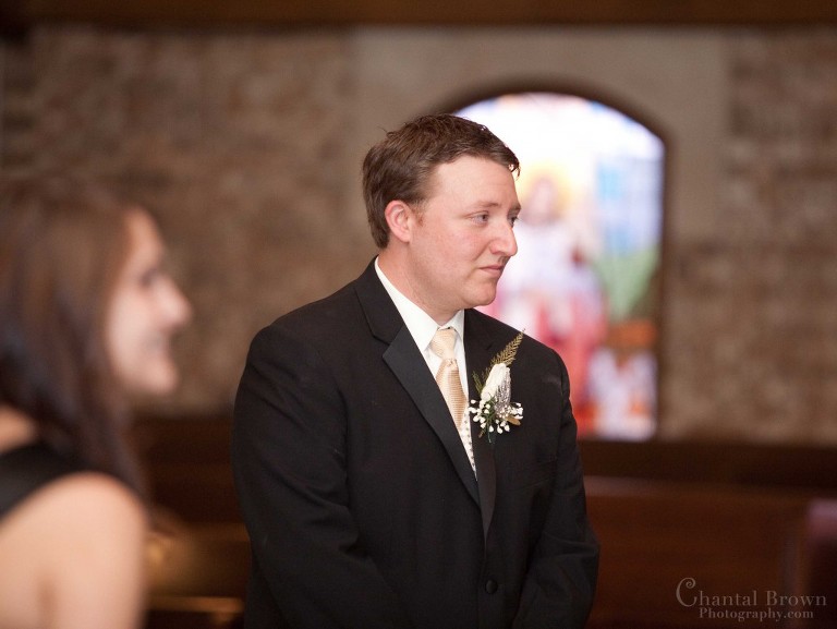 emotional groom watching bride walking down the isle wedding ceremony in Holy Family Catholic Church in Lawton Oklahoma