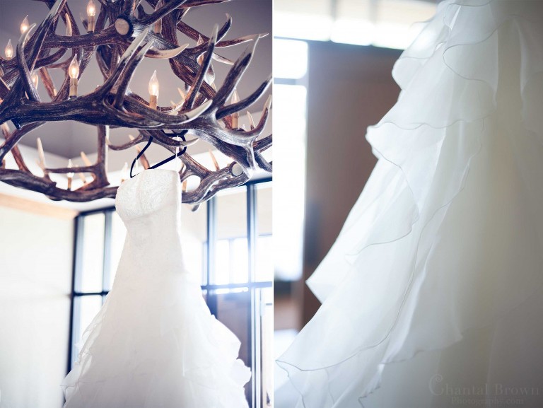 bride wedding dress designed by Alfred Angelo hanging on antlers chandleliers in Lawton Country Club golf course