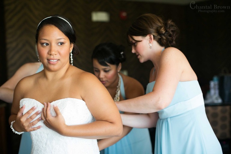 bride putting on wedding dress designed by Alfred Angelo at Lawton country club oklahoma