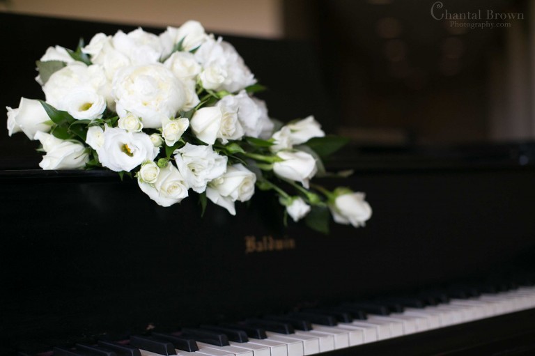 white flowers bouquet on black piano in Lawton Country Club Golf Club in Oklahoma