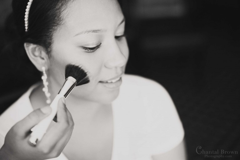 bride black and white picture putting blush on at lawton country club getting ready for wedding
