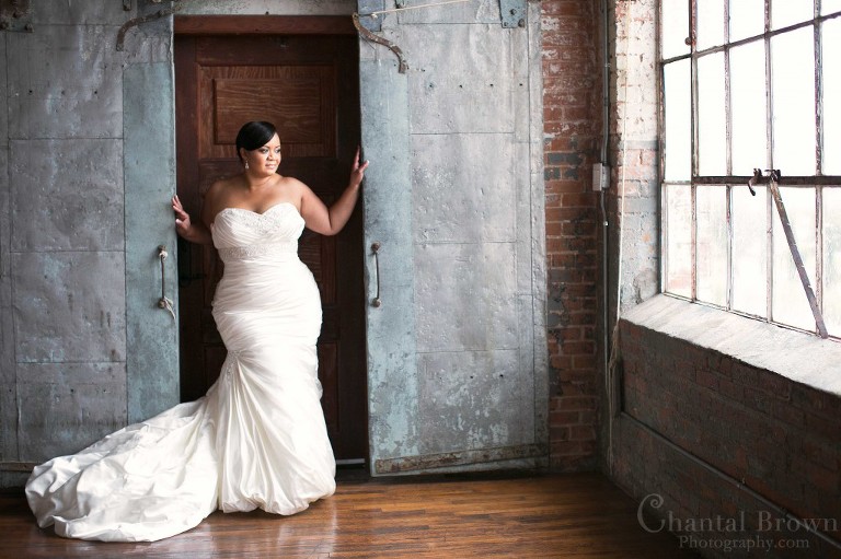 McKinney Bridal Portrait Photographer Chantal Brown Photography Anita standing between steel doors and red brick wall inside M Group Studio looking out in the rain
