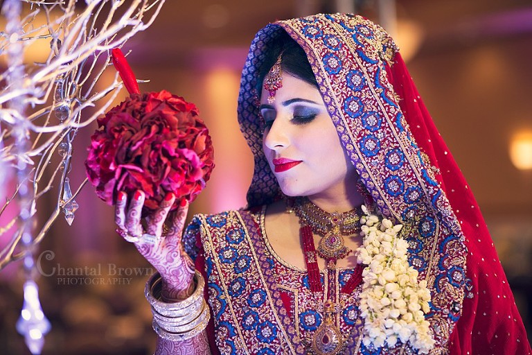 Indian Wedding bride in red diamonds sari saree holding gorgeous red flowers at Richardson Renaissance Hotel in Texas