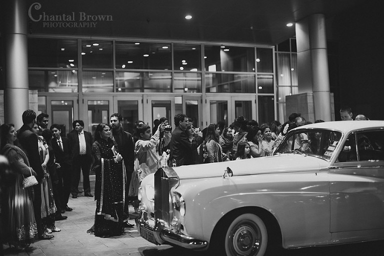 Indian wedding bride crying black and white picture in white Roll Royce car at Marriott Renaissance hotel in Richardson Texas leaving reception ceremony