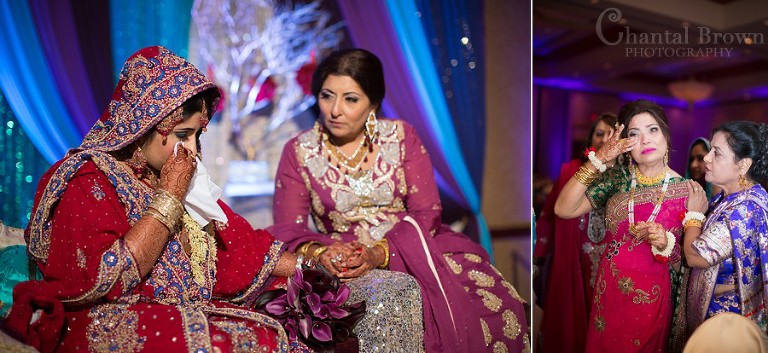 Bride in tears holding mother's hand Indian wedding wearing gorgeous red gold embroidery saree at Marriott Renaissance hotel in Richardson Texas