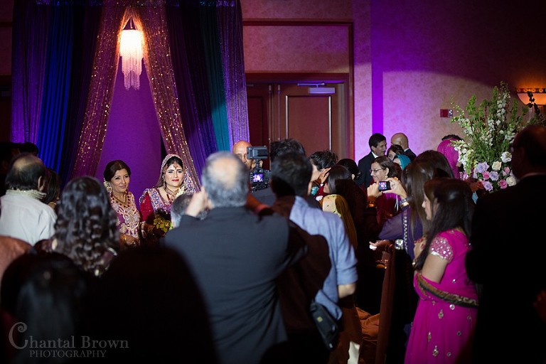 Indian wedding bride with mom entering ceremony wearing red glitter wedding dress sari at Marriott Renaissance hotel in Richardson Texas