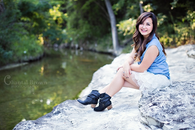 Wylie senior portraits setting on white rock by a creek at Breckinridge Park Richardson Texas