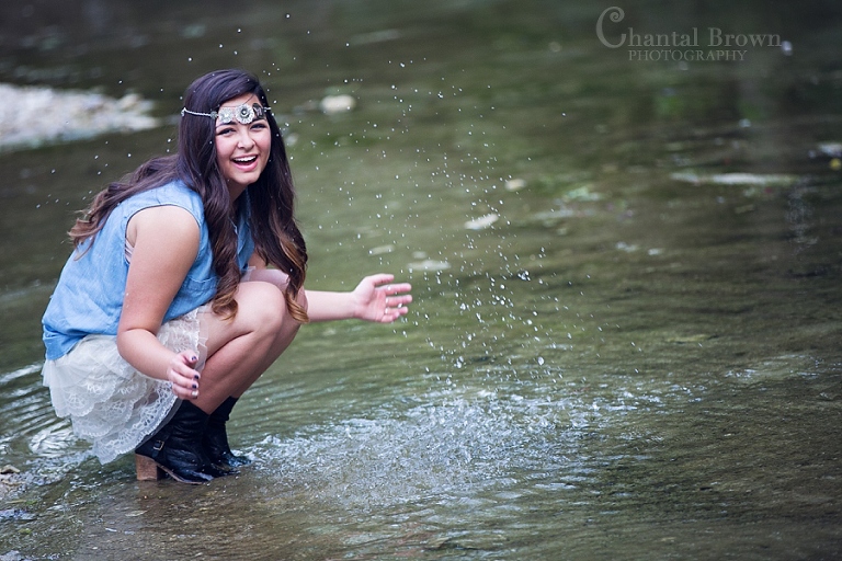 High school senior portraits a girl having fun splashing in the river Wylie Texas photographer