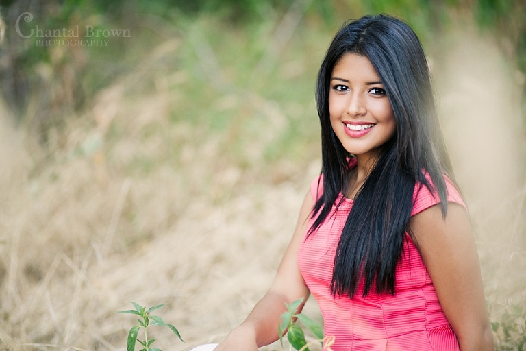 Setting at the park in a grassy field smiling for dallas senior portraits photographer