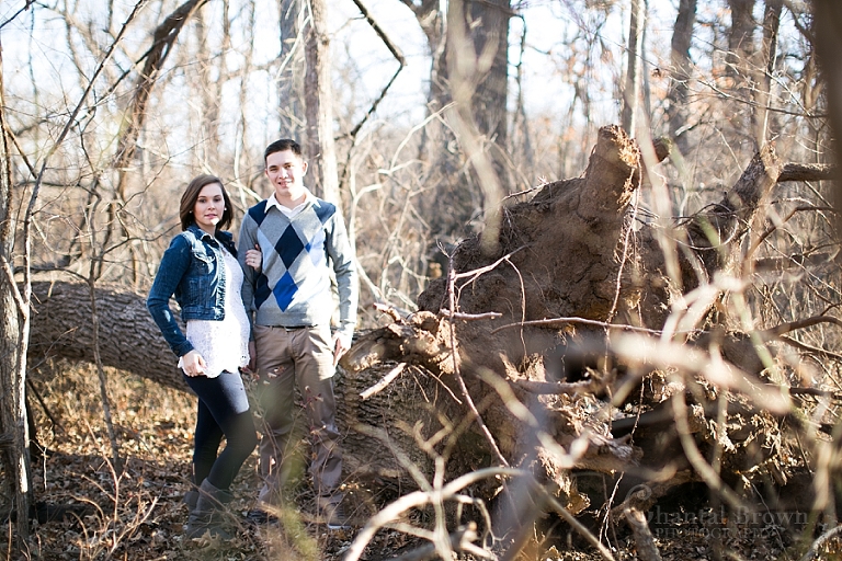 Lawton engagement pictures in the forest by dried tree trunk in fort sill forest by Chantal Brown Photography