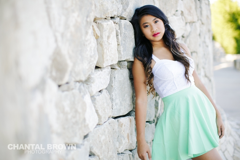 Carrollton TX Senior Pictures by Chantal Brown Photography taken in McKinney Texas at Adriatica leaning on a rock wall.
