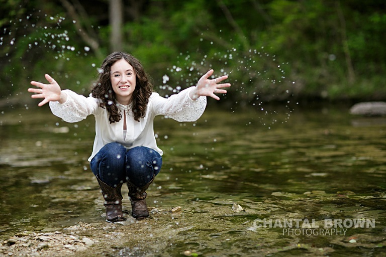 Dallas high school senior picture splashing water in a creek taken by Chantal Brown Photography