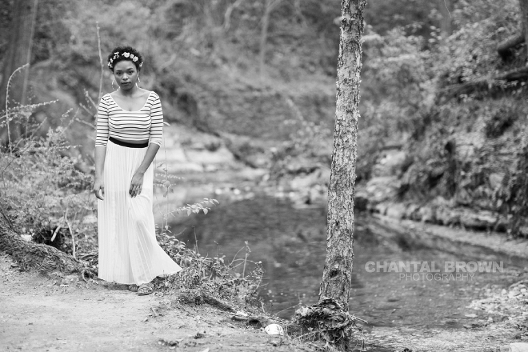 Outdoor Red Oak High School senior portraits at Highland Park in Dallas Texas by water creeks and big tall trees with gorgeous flower head band in black and white photo