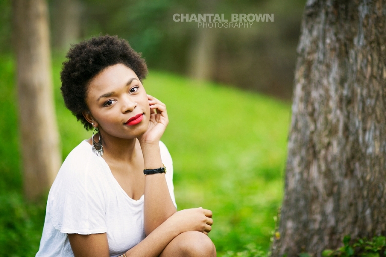 Dallas senior pictures taken at Highland Park Texas setting on a cloud of beautiful grass and surrounded with stunning tall trees.  This Dallas high school senior portraits is taken by Chantal Brown Photography.