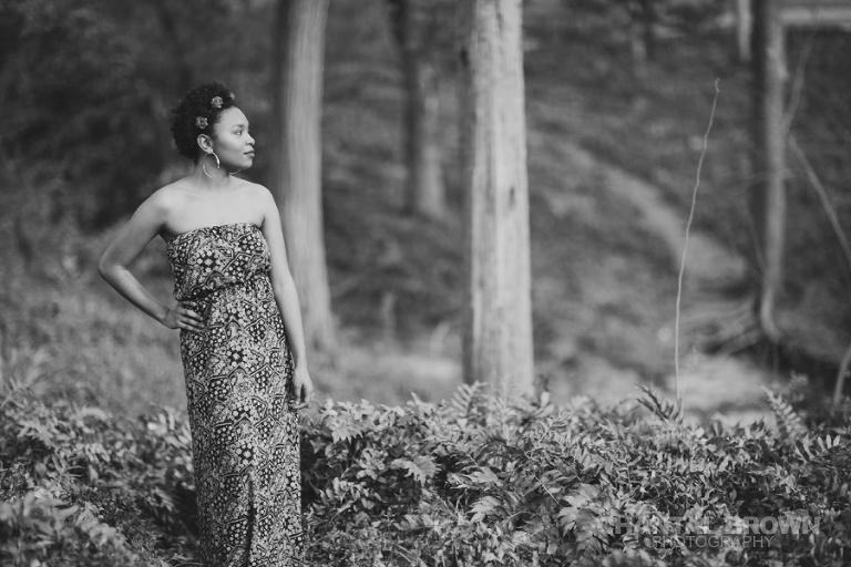 Highland Park Dallas senior portraits of a beautiful high school girl wearing a very pretty red roses head band setting on gorgeous green grass field in black and white picture taken by Chantal Brown Photography