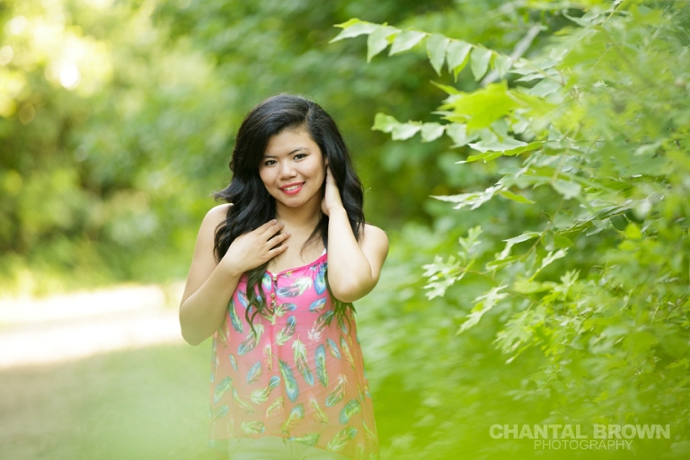 Plano senior photographer of a beautiful portrait of a girl in the green grass field at the park by Chantal Brown Photography.