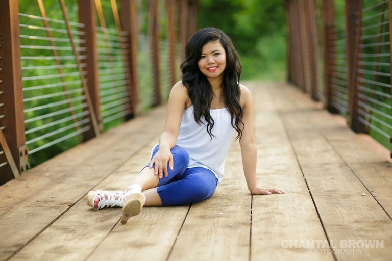 Richardson senior photography of a high school student setting on a bridge at Breckinridge Park by Chantal Brown Photography.