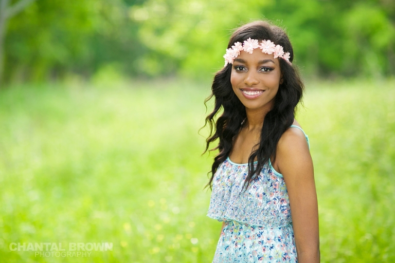 The best senior pictures in Dallas of Wylie East high school senior student wearing gorgeous pink flower head band with baby blue dress standing out in the field taken by Chantal Brown Photography.