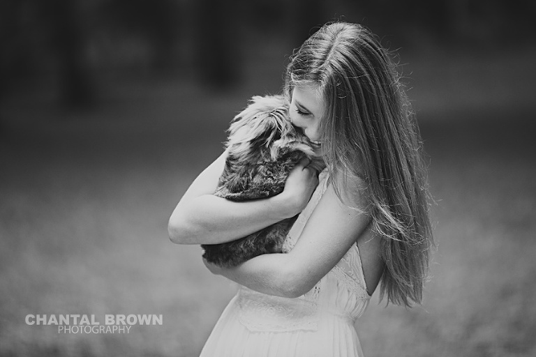 Plano high school senior picture in black and white color holding a rabbit by Chantal Brown Photography.