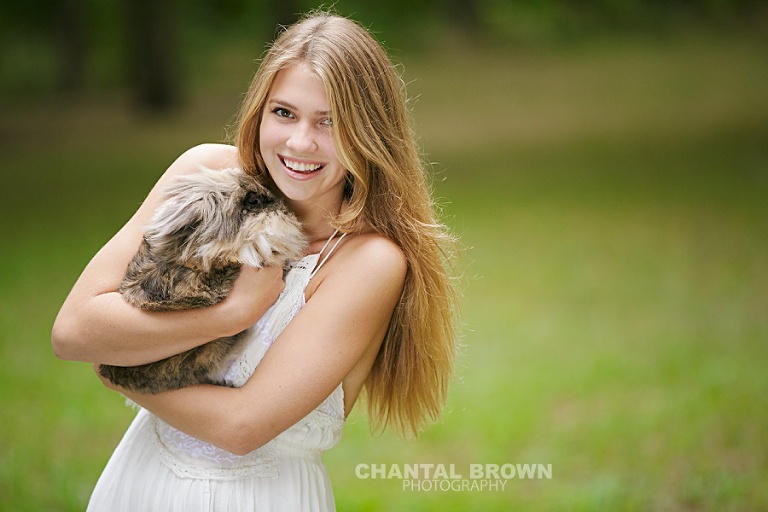 Plano senior portraits outdoor holding a rabbit smiling in the field.