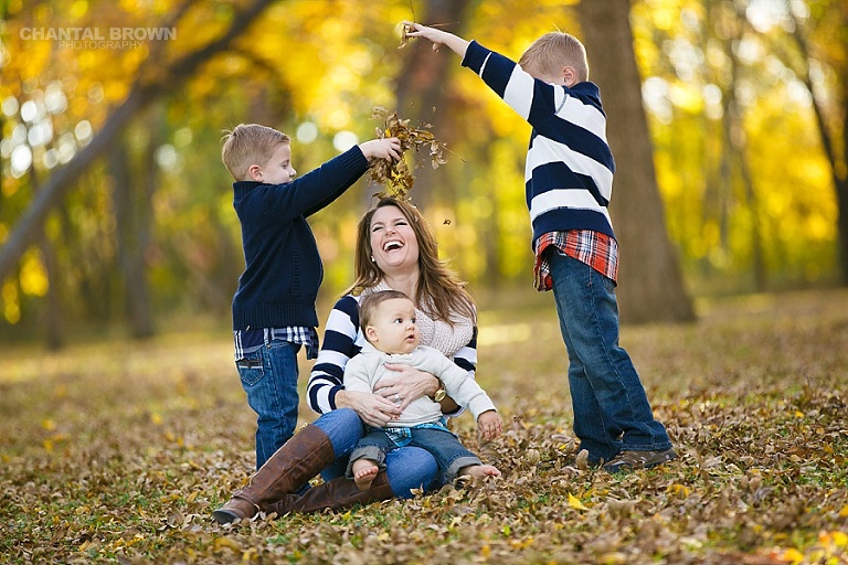 kids and mom laughing while playing in the fall yellow leaves family portrait in Plano TX taken by Chantal Brown Photography