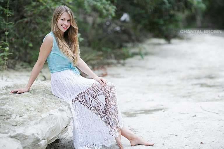 Sitting on white rock for outdoor senior portraits in Addison Texas by Chantal Brown Photography