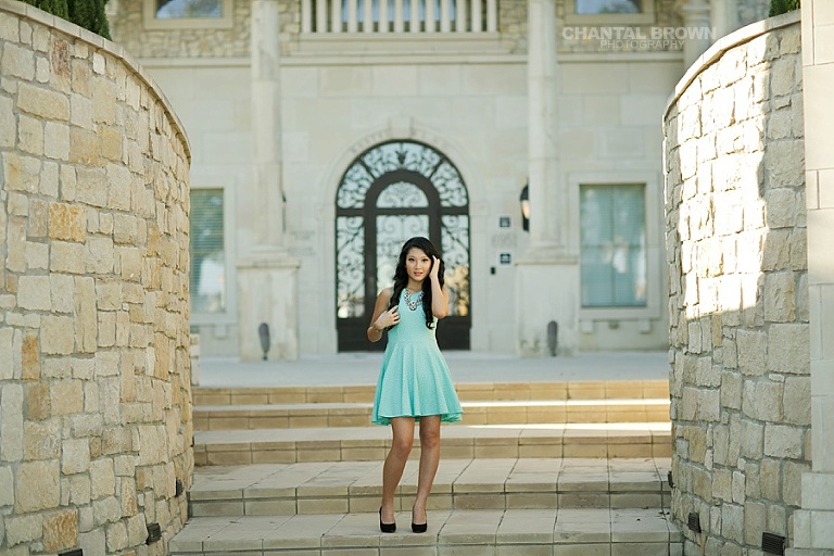 Gorgeous high school senior student standing in the middle of beautiful stone wall architecture taken at Adriatica village in McKinney Texas.