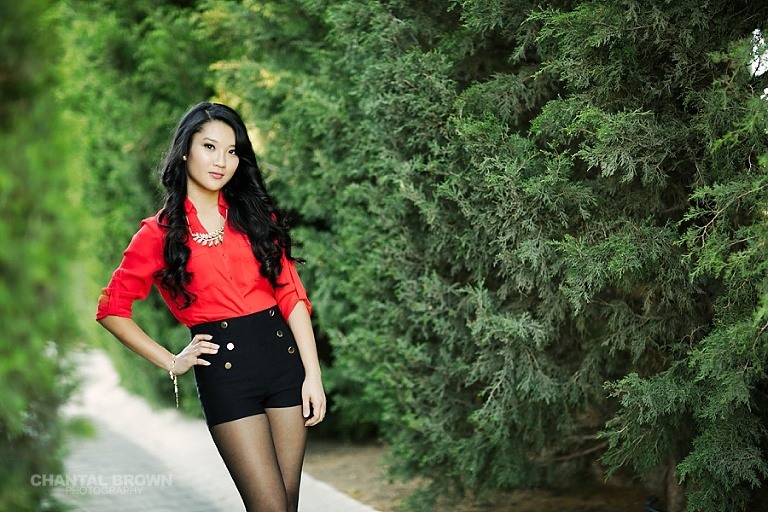 Stunning sunset senior portraits McKinney TX standing next to tall pine trees in Adriatica Village.