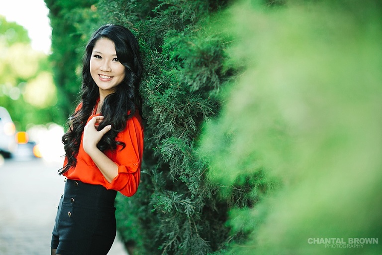Best backlit sunset senior portraits McKinney TX leaning next to beautiful tall pine green pine trees at Adriatica Village by Chantal Brown.