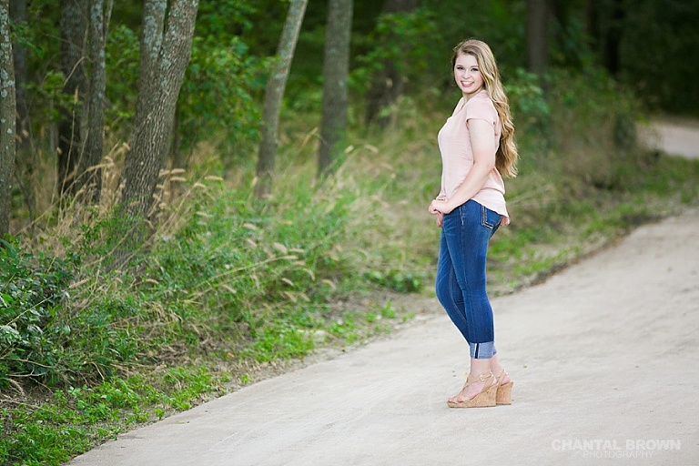 Standing on concrete of the beautiful high school senior portraits taken at Breckinridge Park by Dallas senior portrait photographer Chantal Brown.