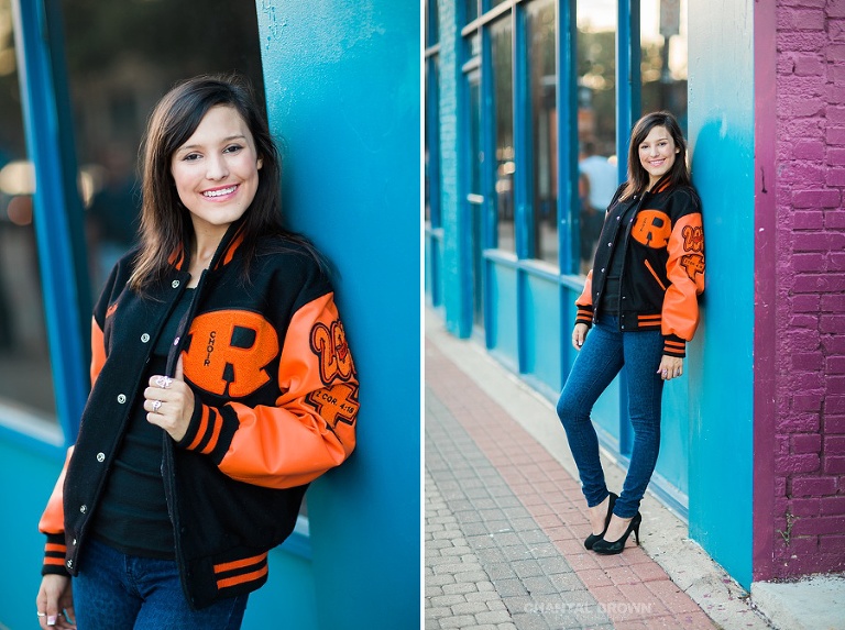 Senior portraits in Deep Ellum Dallas Texas wearing Rockwall high school wearing school letterman jacket, standing next to blue purple wall.