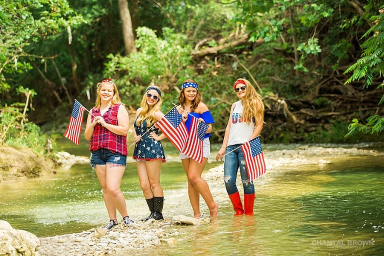 4th of July theed senior portraits group photo shoot in Dallas by the water creek river holding American flags.